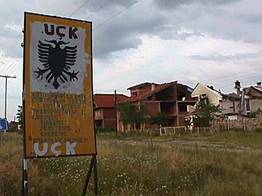 Dorpje met UCK graffiti  op de weg van Prizren naar Pristina (foto Gert Jan Rohmensen, RNW 1999)